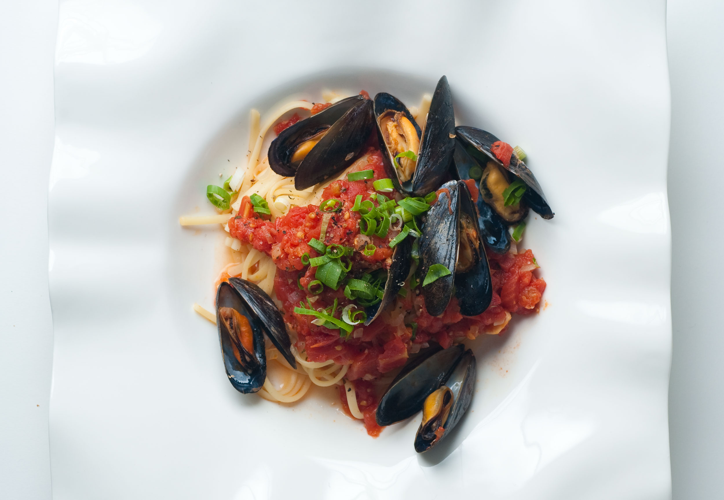 Tomato Basil Mussels Served Over Pasta